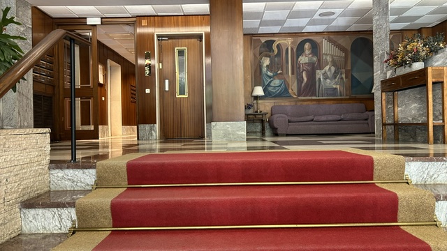 Portal del edificio con escalera y obra de arte