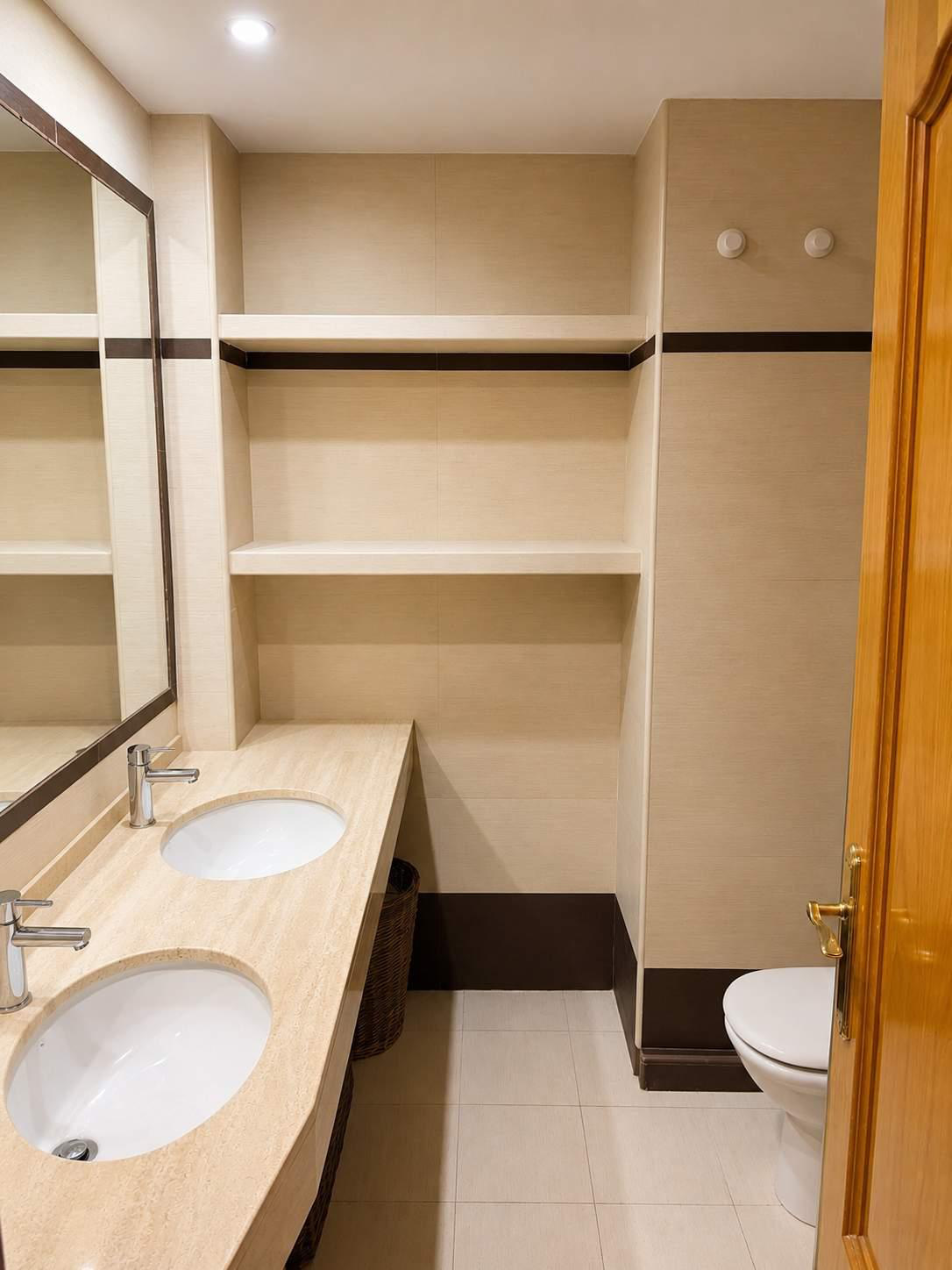 Baño con doble seno y estanterías de obra