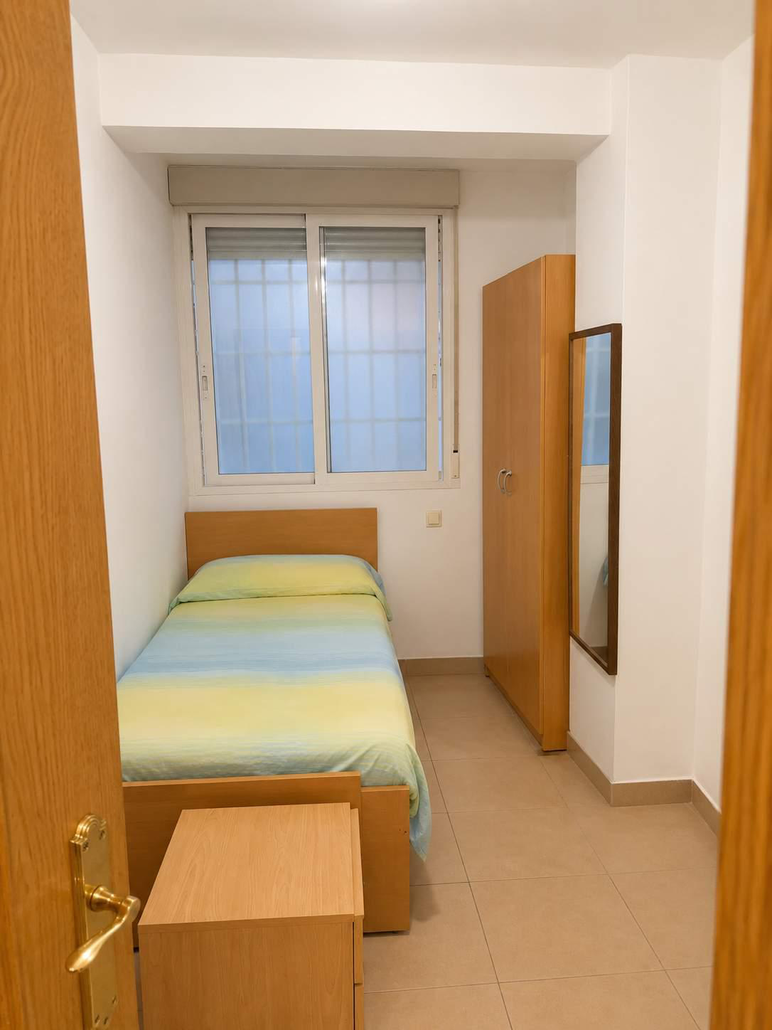 Dormitorio individual con armario y espejo