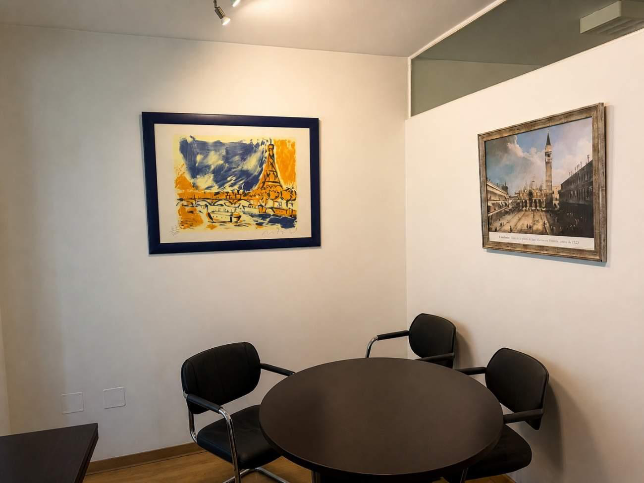 Sala de reuniones del despacho con obras enmarcadas